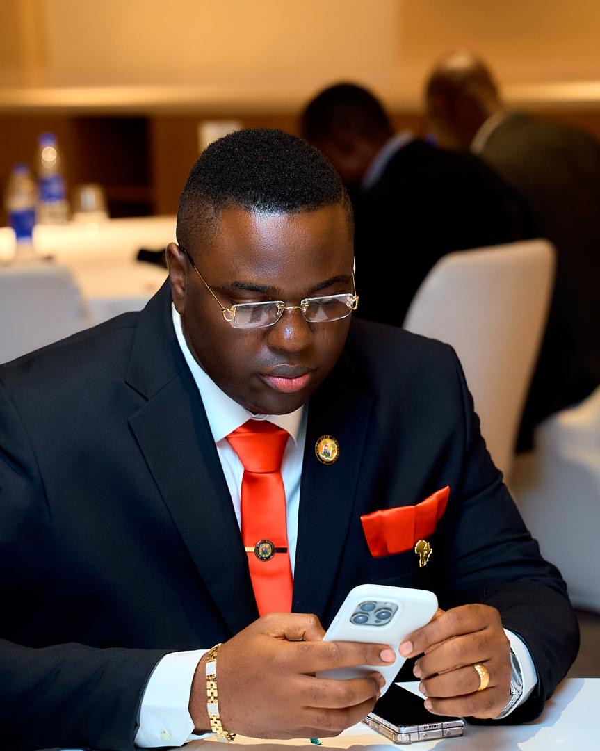 Prince Fuhad Oloto reviewing his phone at an event