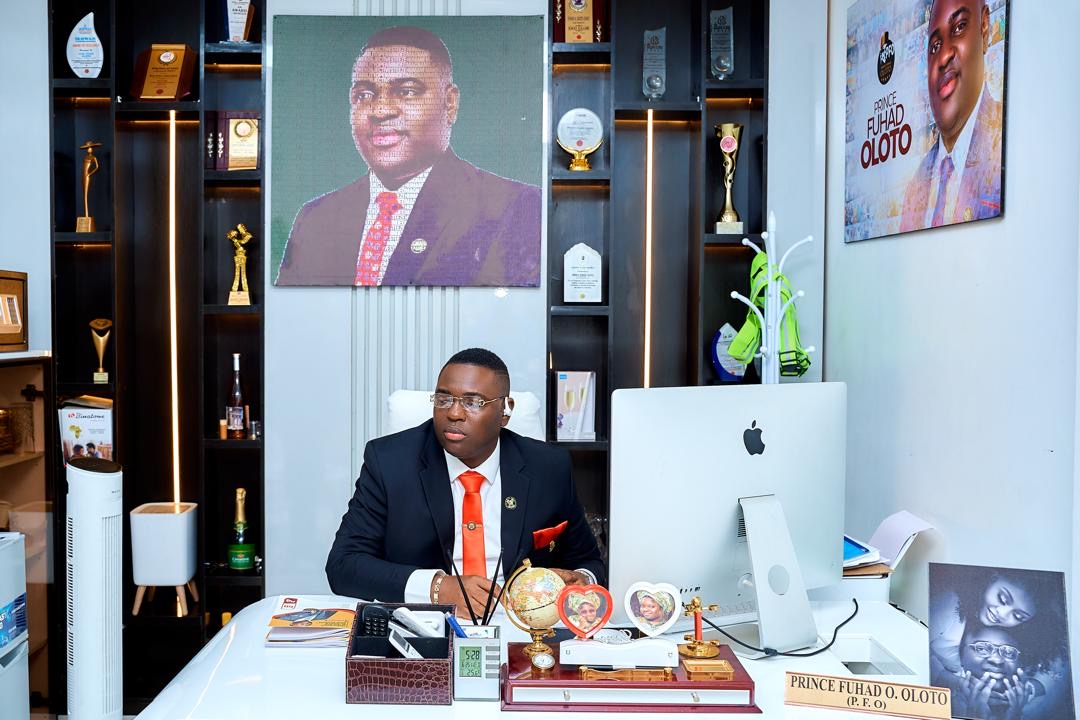 Prince Fuhad Oloto at his office desk with awards