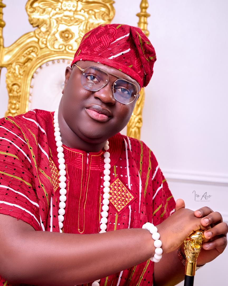 Prince Fuhad Oloto in red royal attire on the throne