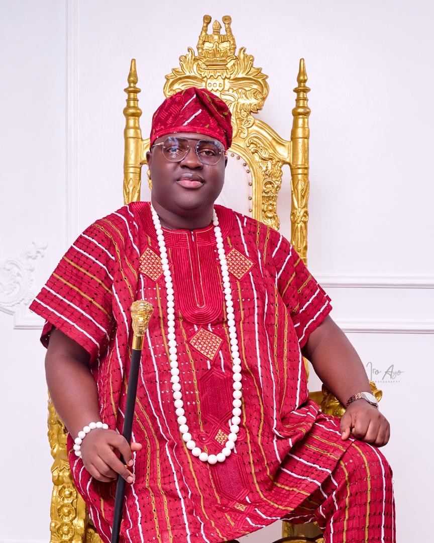 Prince Fuhad Oloto seated on the royal throne in red attire