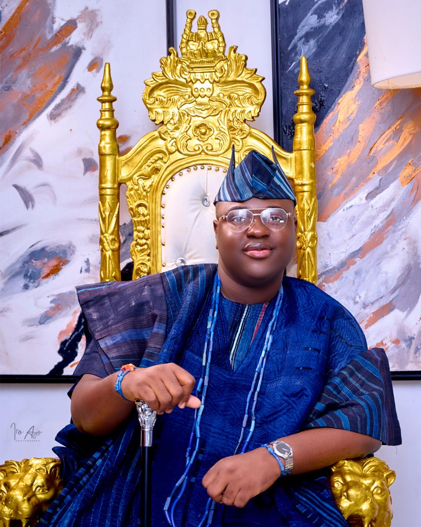 Prince Fuhad Oloto in blue royal attire on the throne