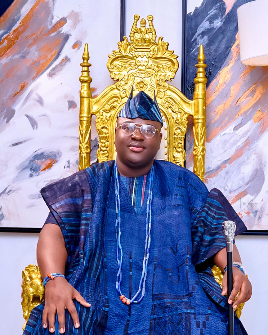 Prince Fuhad Oloto seated on the gold throne in blue attire