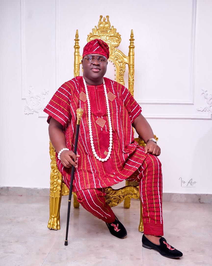 Prince Fuhad Oloto seated on the royal throne in red attire