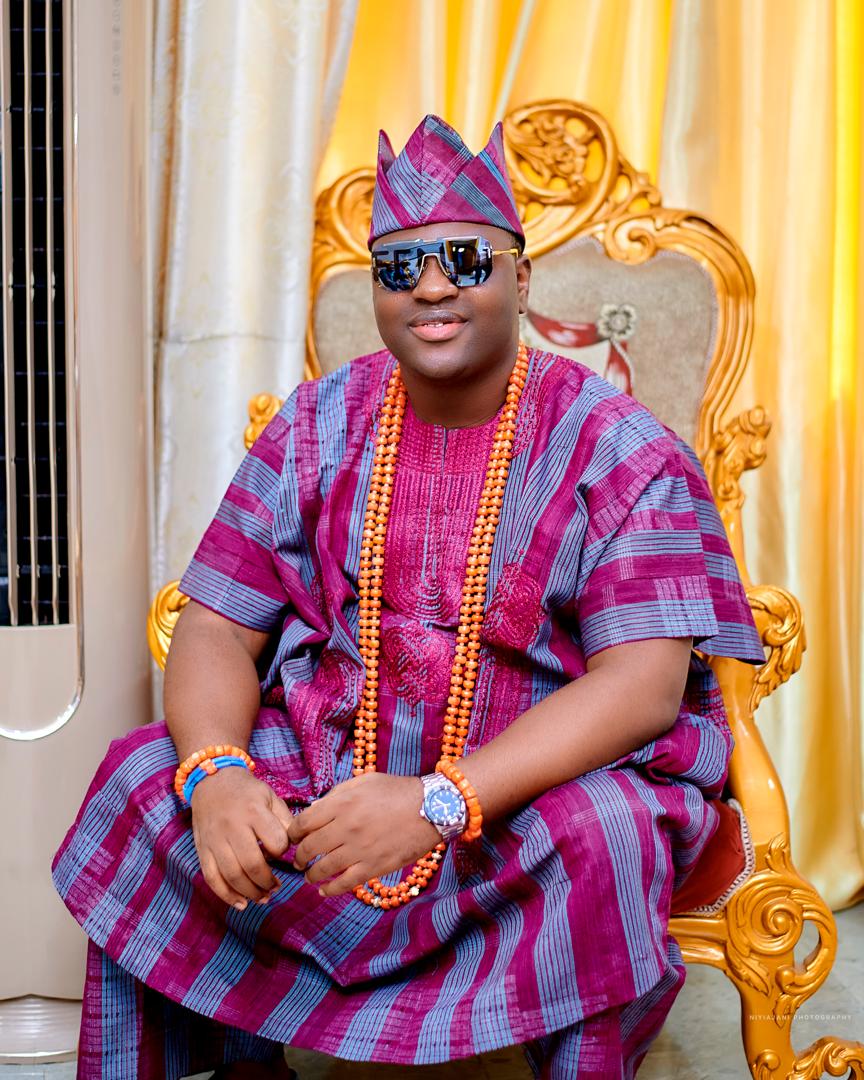 Prince Fuhad Oloto in magenta royal attire on the throne